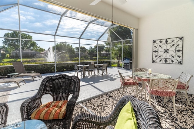 view of patio / terrace with glass enclosure, outdoor dining space, and a grill