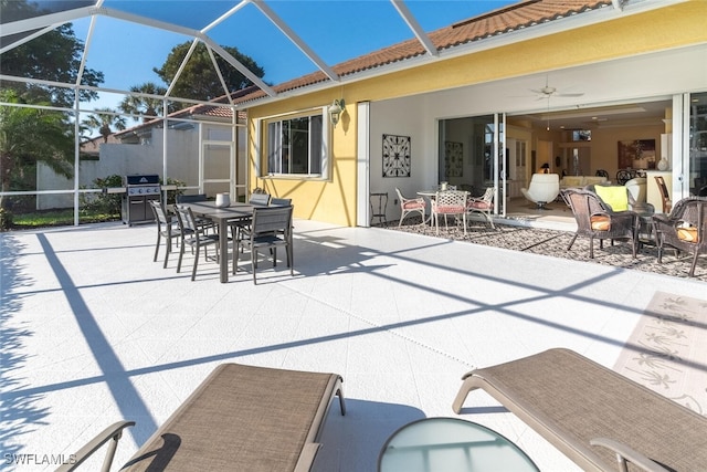 view of patio featuring grilling area, glass enclosure, and outdoor dining area