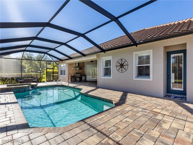 view of swimming pool featuring glass enclosure, a patio area, and a pool with connected hot tub