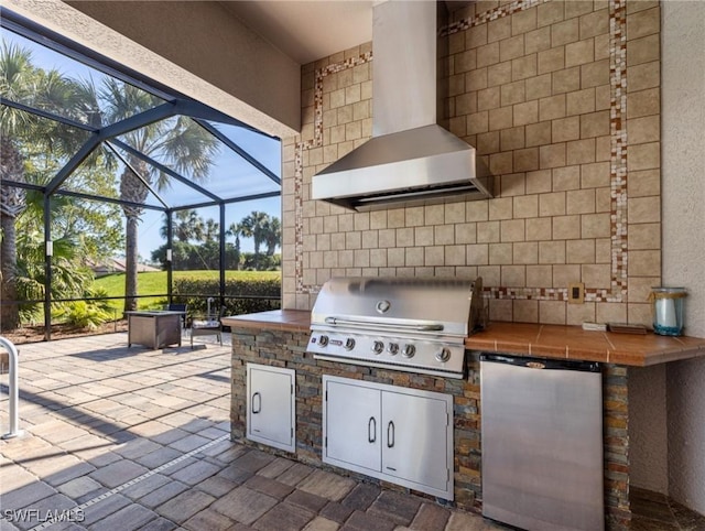 view of patio / terrace featuring exterior kitchen, a lanai, and grilling area