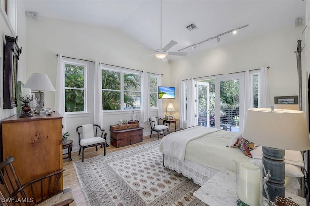 3643 N Rd, Naples, FL 34104 - bedroom featuring visible vents, rail lighting, lofted ceiling, access to exterior, and light wood-type flooring