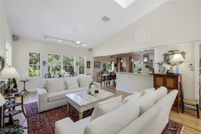 3643 N Rd, Naples, FL 34104 - living area with high vaulted ceiling, baseboards, visible vents, light wood-style floors, and an inviting chandelier