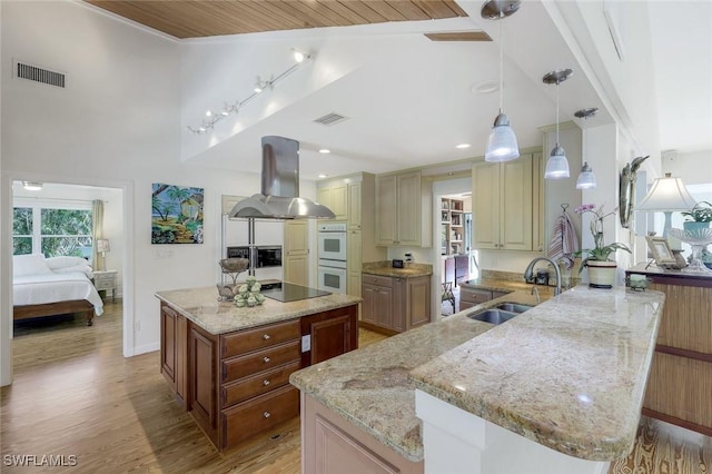 3643 N Rd, Naples, FL 34104 - kitchen featuring island exhaust hood, double oven, visible vents, and a sink