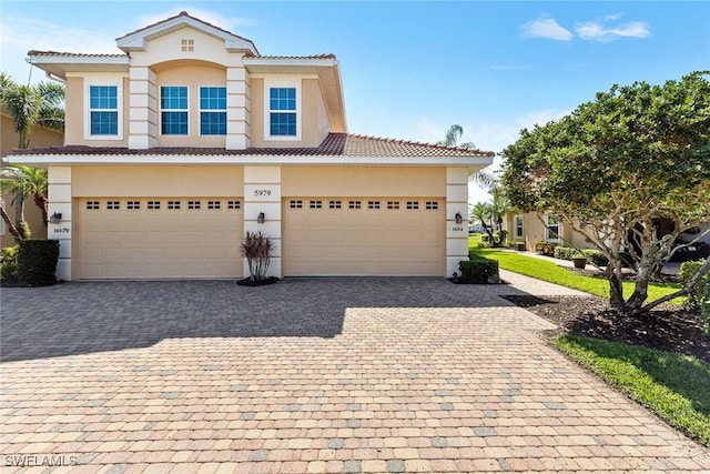 view of front facade with stucco siding, decorative driveway, and a tile roof