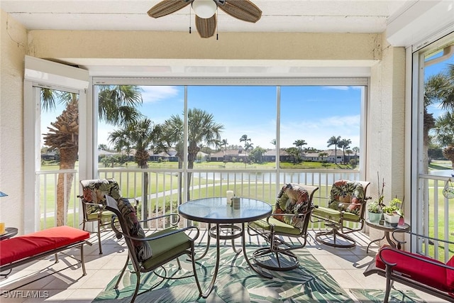 sunroom / solarium featuring a water view, a healthy amount of sunlight, and ceiling fan