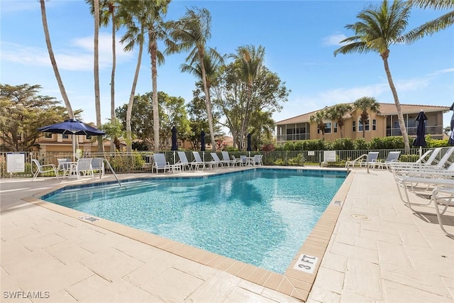 community pool featuring a patio and fence