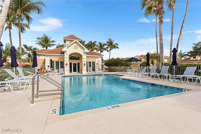 pool with a patio area and fence