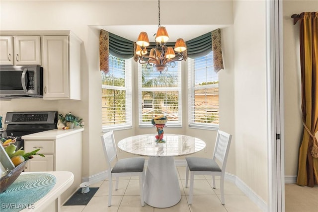 dining area featuring light tile patterned floors, baseboards, and a notable chandelier