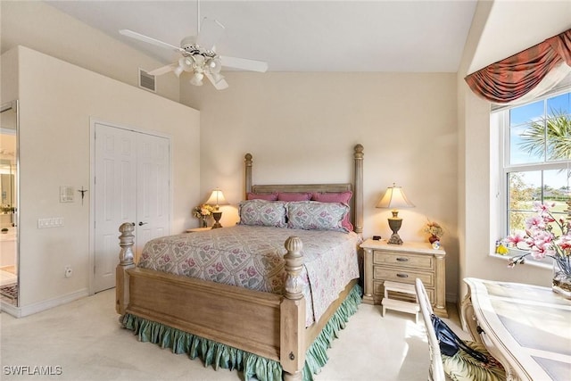 bedroom with visible vents, light carpet, a ceiling fan, a closet, and vaulted ceiling