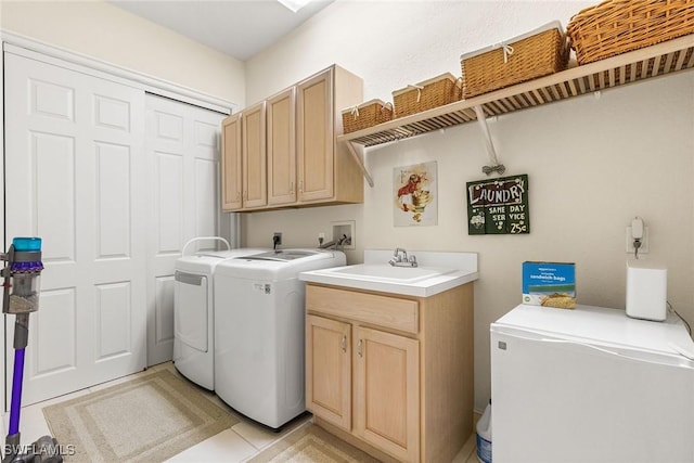 laundry area with cabinet space, washing machine and dryer, and a sink