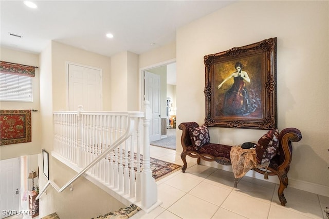 hall featuring visible vents, baseboards, recessed lighting, tile patterned flooring, and an upstairs landing