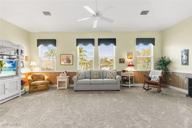 living room featuring visible vents, plenty of natural light, carpet flooring, and wainscoting