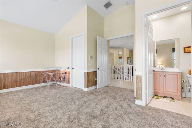 5979 Trophy Dr Unit 1604, Naples, FL 34110 - carpeted spare room with vaulted ceiling and a wainscoted wall