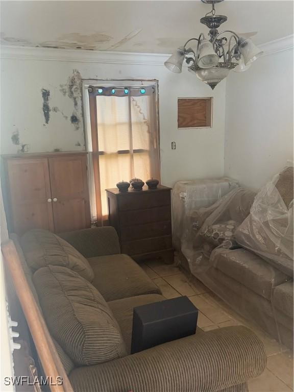 living room featuring light tile patterned floors, a notable chandelier, and ornamental molding