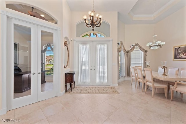 foyer entrance with a chandelier, french doors, and a high ceiling