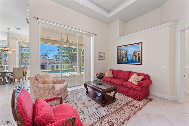 living room with a wealth of natural light, a tray ceiling, baseboards, and crown molding