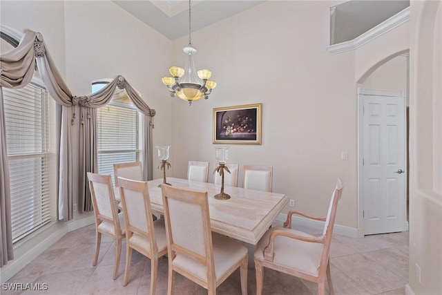 dining area with a notable chandelier, light tile patterned flooring, baseboards, and high vaulted ceiling