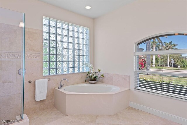 full bath with tile patterned flooring, a shower stall, a garden tub, and a healthy amount of sunlight