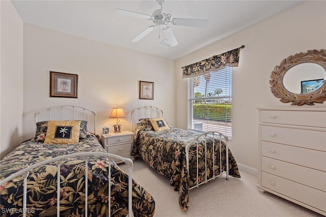 bedroom with ceiling fan, baseboards, and light carpet