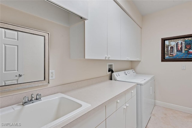 laundry room featuring baseboards, washing machine and dryer, light tile patterned floors, cabinet space, and a sink