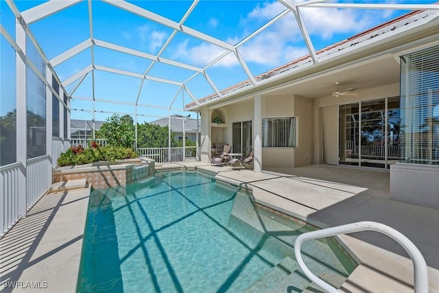 view of pool with a lanai, ceiling fan, a pool with connected hot tub, and a patio