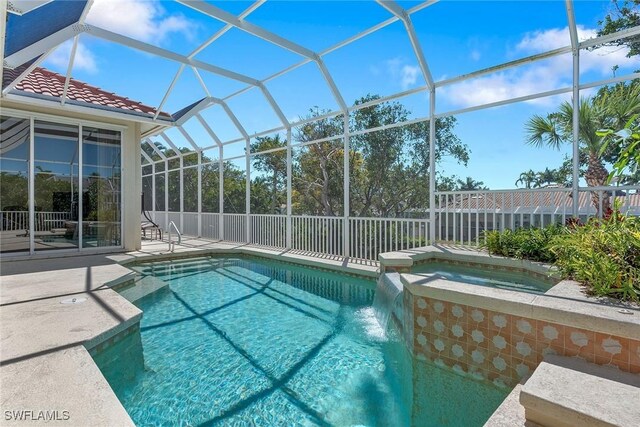 view of swimming pool featuring a lanai, a patio area, and a pool with connected hot tub