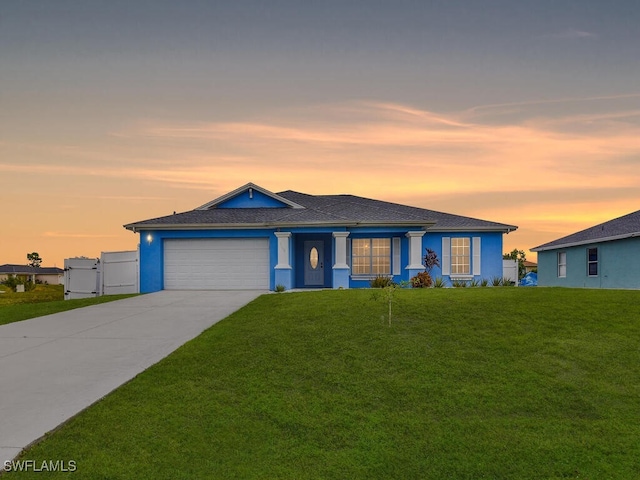 ranch-style house featuring stucco siding, driveway, a front yard, and an attached garage