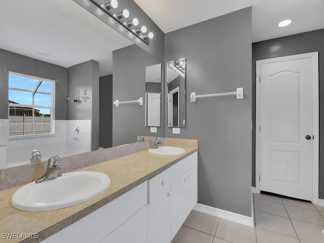 bathroom featuring a sink, baseboards, double vanity, and tile patterned floors