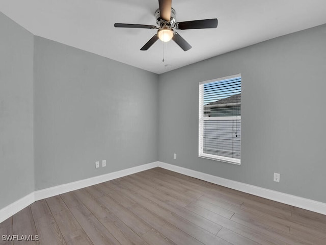 spare room with wood finished floors, baseboards, and ceiling fan