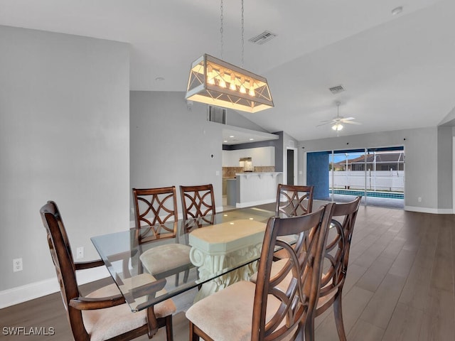 dining space featuring visible vents, baseboards, lofted ceiling, wood finished floors, and a ceiling fan