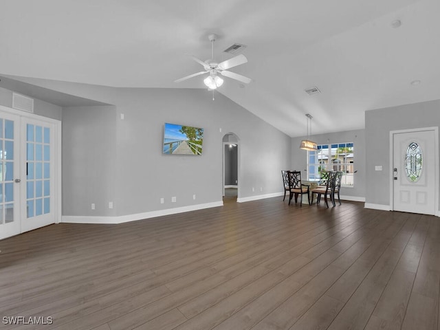 unfurnished living room featuring baseboards, visible vents, dark wood-style flooring, arched walkways, and french doors