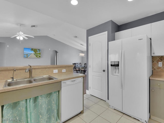 kitchen with a sink, backsplash, white appliances, light countertops, and light tile patterned floors