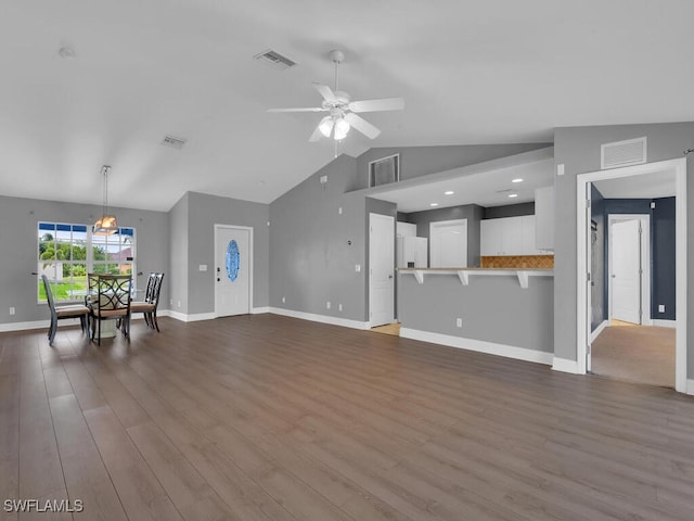 unfurnished living room featuring visible vents, dark wood-type flooring, ceiling fan, and vaulted ceiling