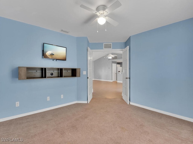 empty room with visible vents, baseboards, carpet, and ceiling fan