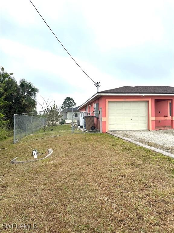 exterior space with an attached garage, a yard, and fence