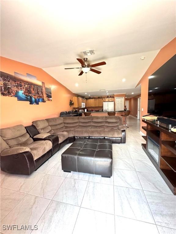 living room with visible vents, marble finish floor, ceiling fan, and vaulted ceiling