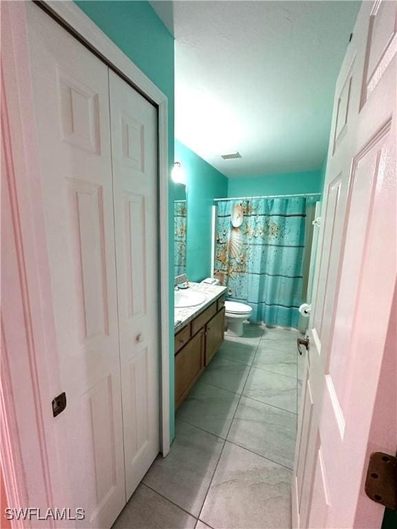 bathroom featuring vanity, a shower with shower curtain, visible vents, tile patterned flooring, and toilet