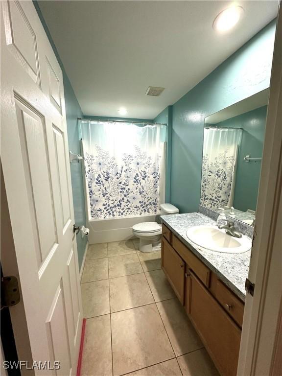 full bath featuring vanity, visible vents, shower / bath combo with shower curtain, tile patterned floors, and toilet