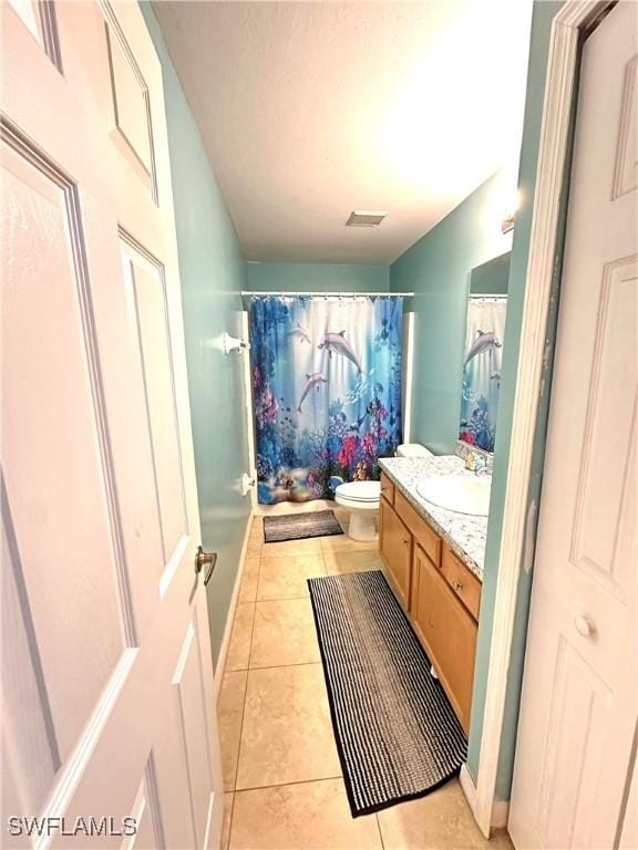 full bath with visible vents, baseboards, toilet, tile patterned floors, and vanity