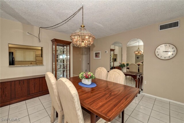 dining room with a chandelier, visible vents, and a textured ceiling