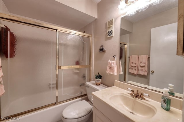 full bathroom with visible vents, vanity, toilet, and bath / shower combo with glass door