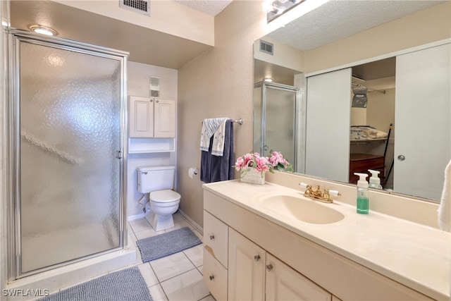 bathroom featuring a textured ceiling, toilet, visible vents, and a stall shower