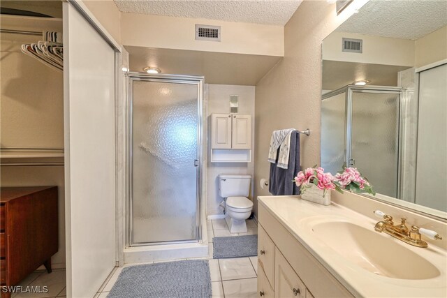 full bath with visible vents, toilet, vanity, a stall shower, and a textured ceiling