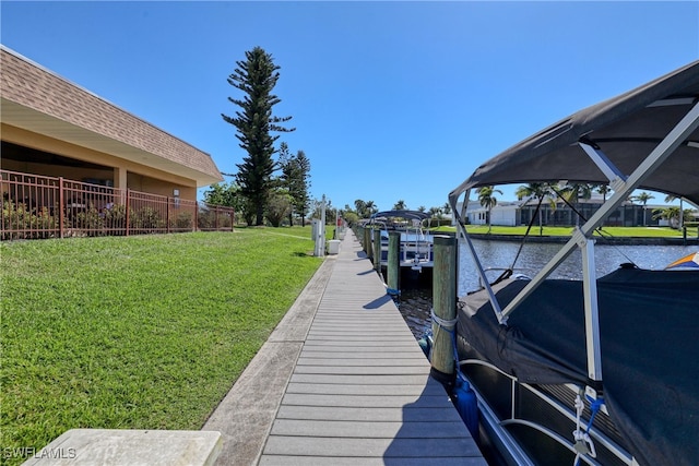 view of dock with glass enclosure, a yard, and a water view