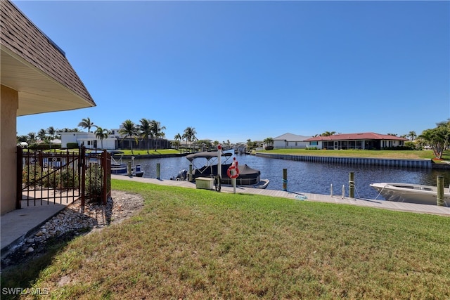 dock area featuring a residential view, a water view, and a lawn