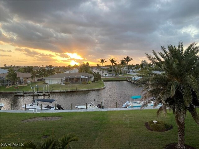 exterior space with a yard, a water view, and boat lift