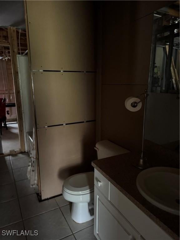 bathroom featuring tile patterned flooring, toilet, and vanity