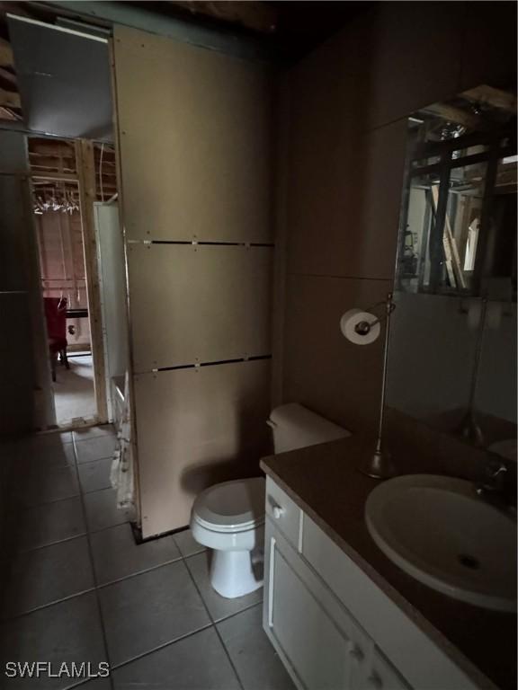 bathroom featuring tile patterned flooring, toilet, and vanity