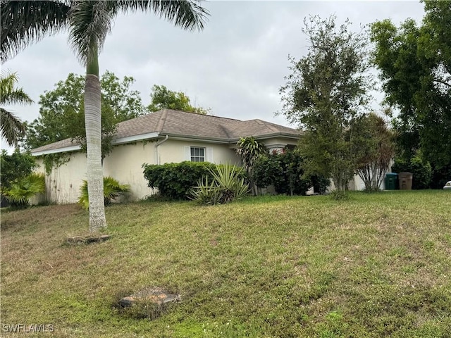 view of property exterior featuring stucco siding and a yard