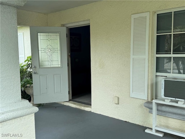 doorway to property with stucco siding and cooling unit